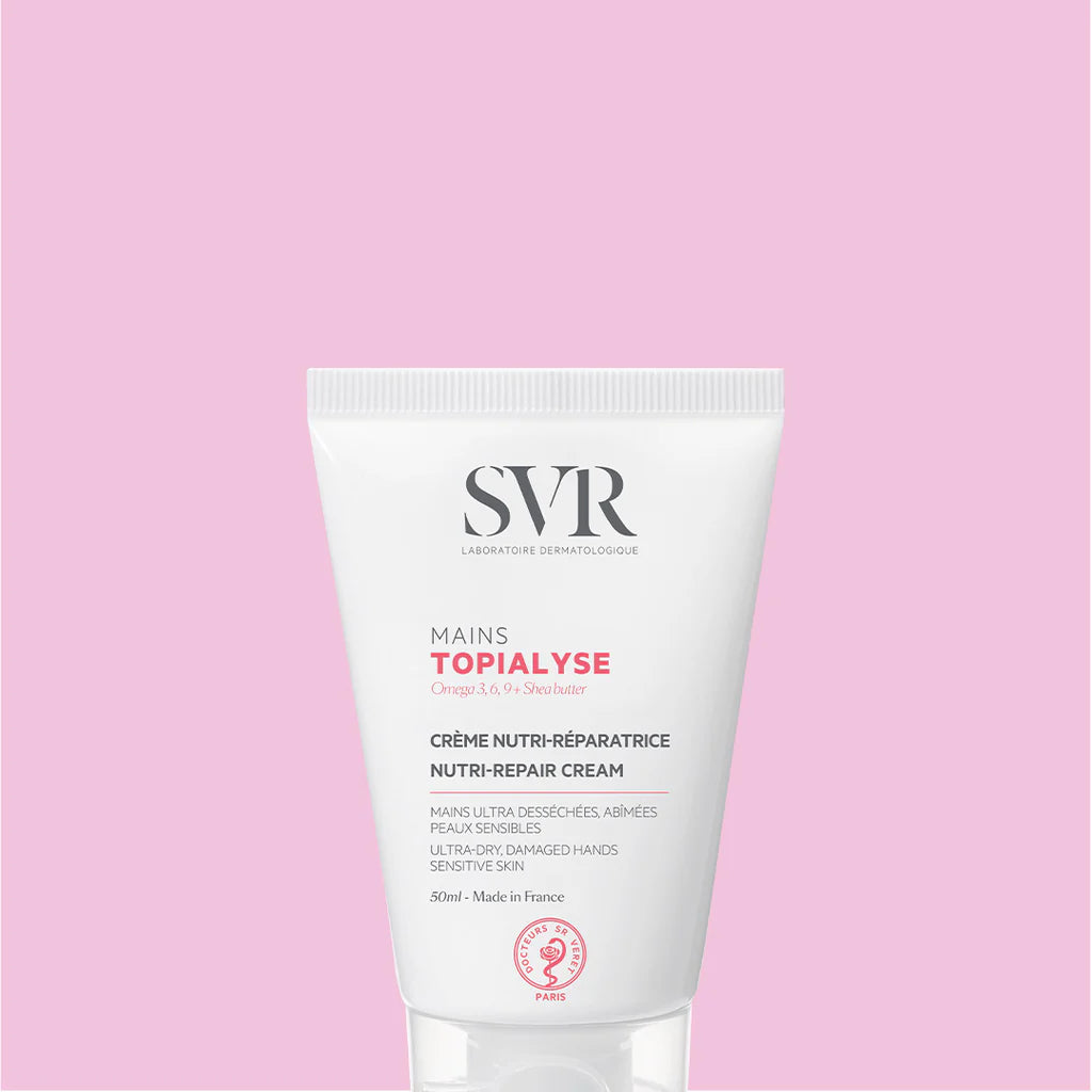 Tubo de crema reparadora de manos SVR Topialyse de 50ml en envase blanco con letras negras sobre fondo rosa claro.