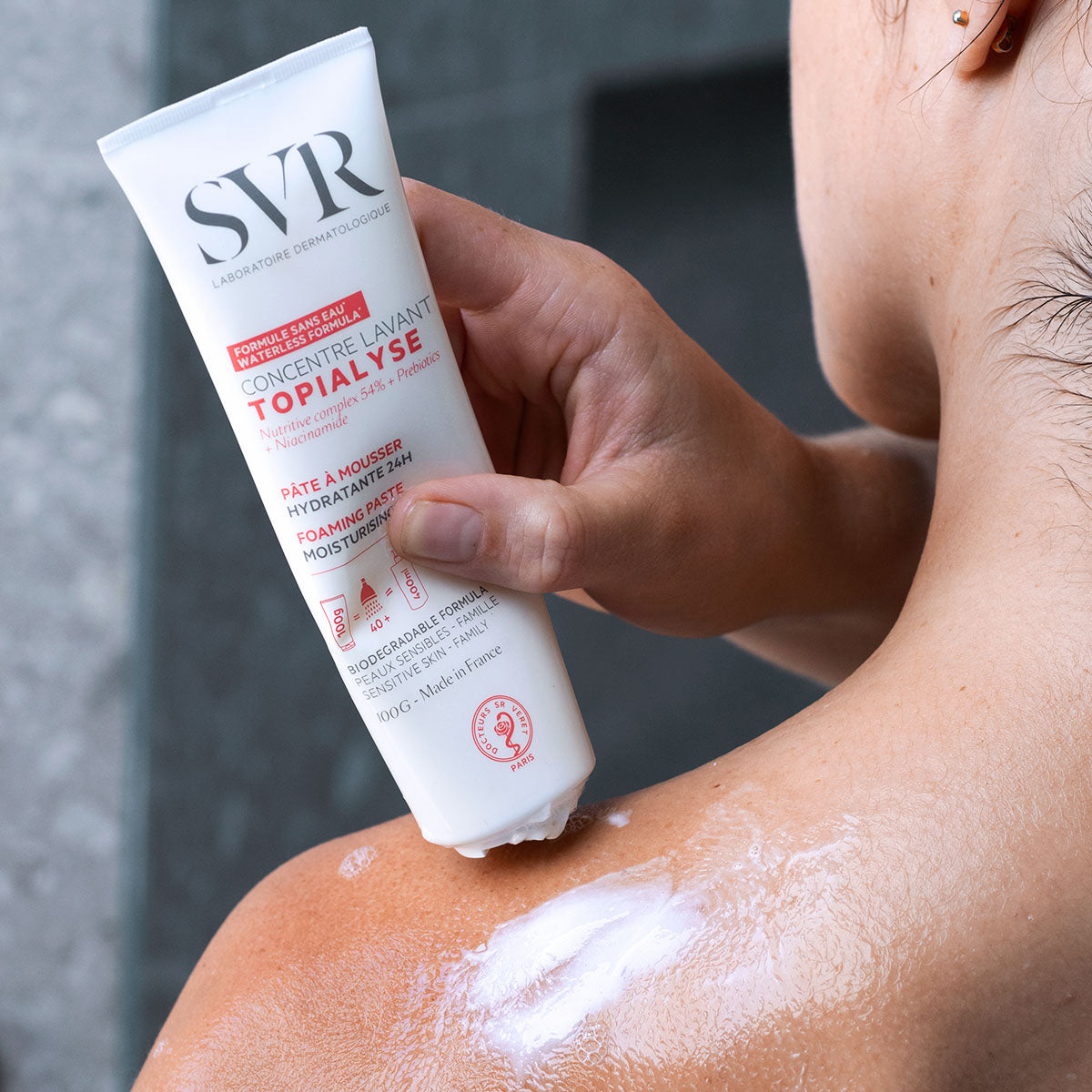 SVR TOPIALYSE Concentré Lavant white tube being applied to wet skin to create a gentle, moisturizing foam.