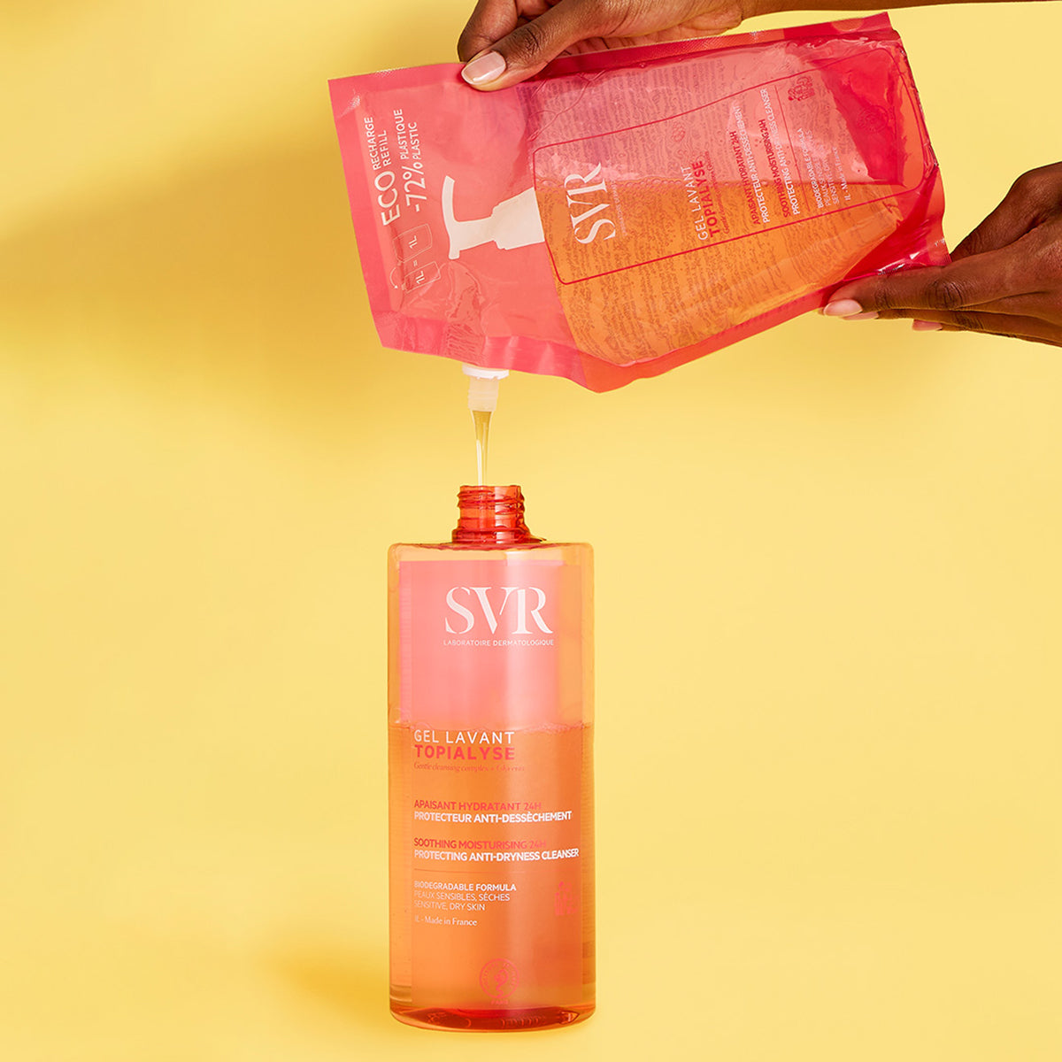 Recarga de gel limpiador SVR Topialyse vertiéndose en un envase transparente sobre fondo amarillo.