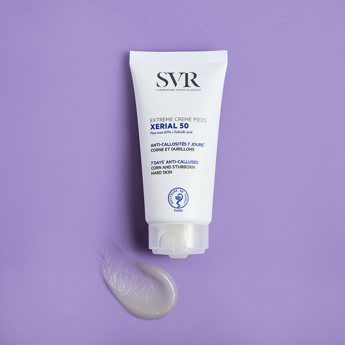 Tubo blanco de crema SVR Xerial 50 para pies con una muestra de producto sobre fondo lila.