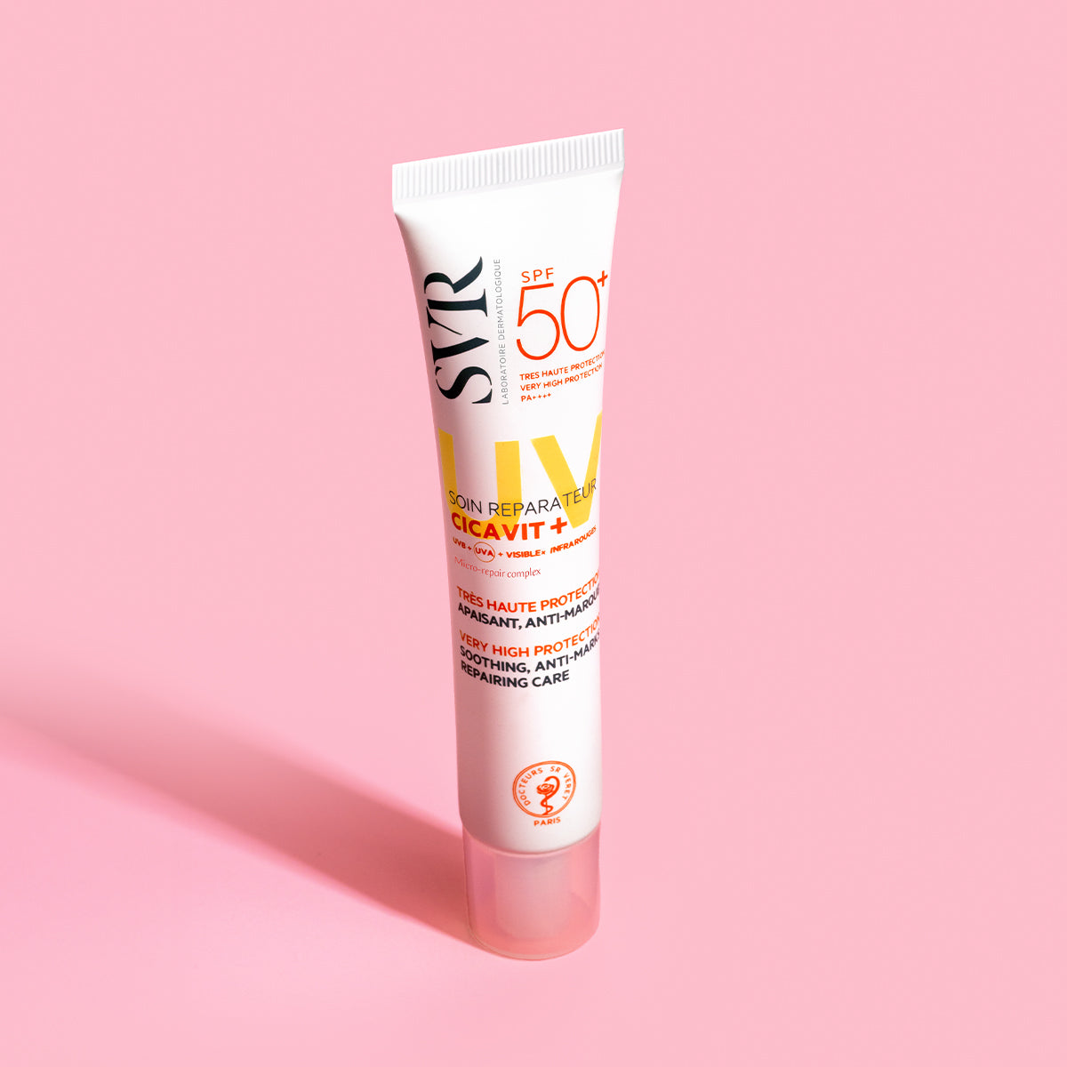 Tubo blanco de crema reparadora SVR Cicavit+ SPF50+ sobre fondo rosa, destacando protección solar y cuidado dermatológico.