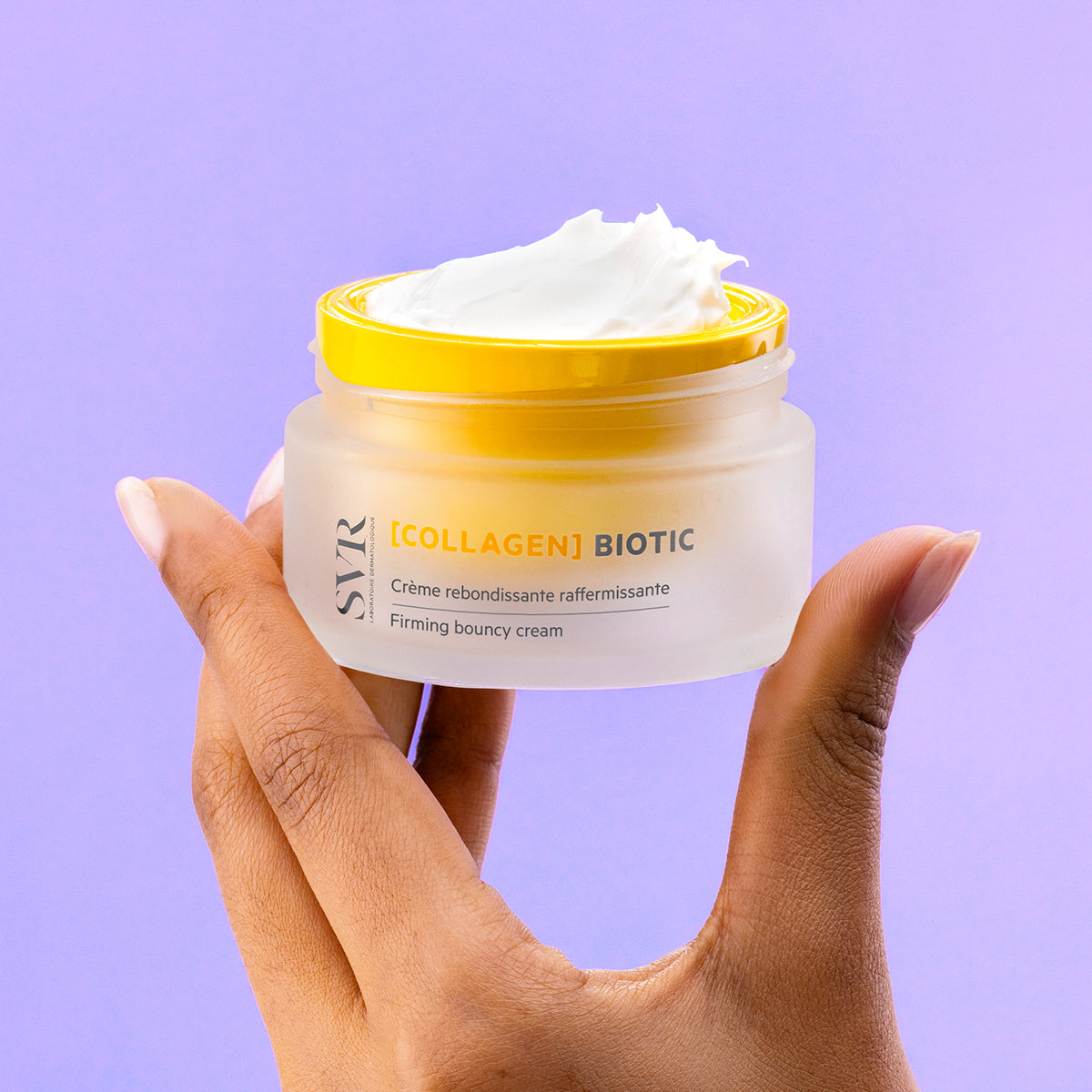 Tarro de crema reafirmante SVR [COLLAGEN] Biotic con tapa amarilla y textura cremosa sobre fondo lila.