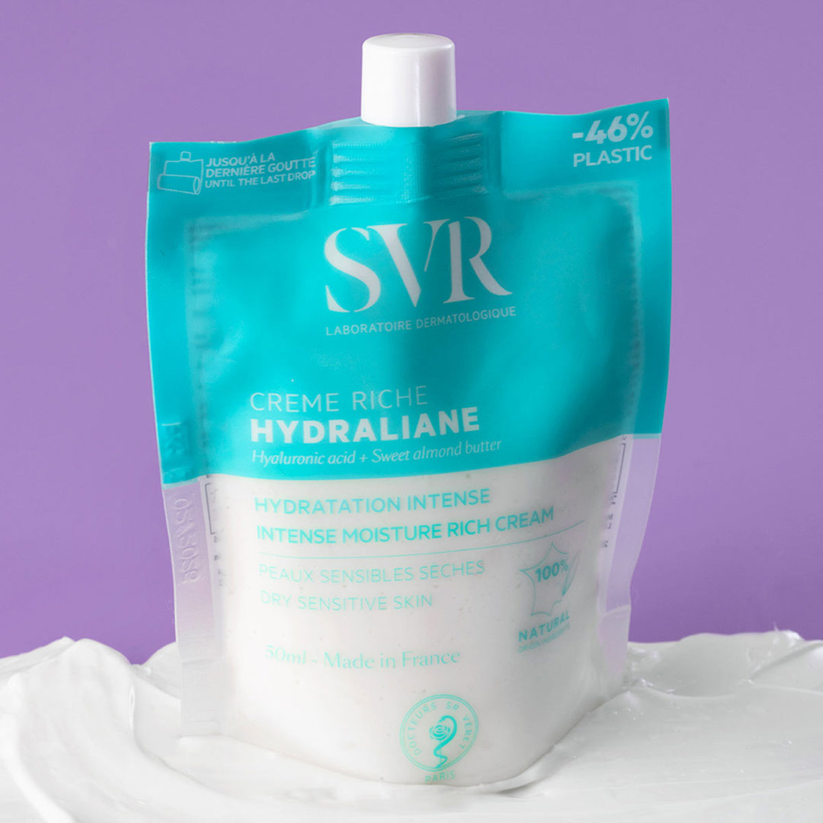 Envase flexible de SVR Hydraliane Riche sobre una base de crema blanca, con diseño azul turquesa y acabado mate.