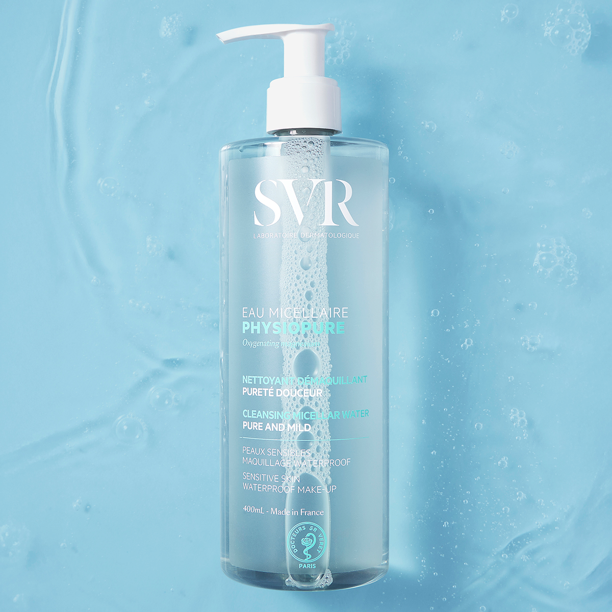 Frasco de 400ml de agua micelar SVR PHYSIOPURE con dosificador sobre un fondo azul con burbujas de agua.