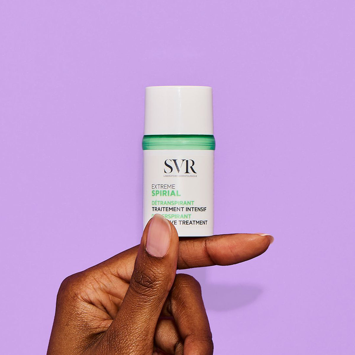 Antitranspirante SVR Spirial Extreme en envase blanco con tapa verde, sostenido por una mano sobre fondo morado.