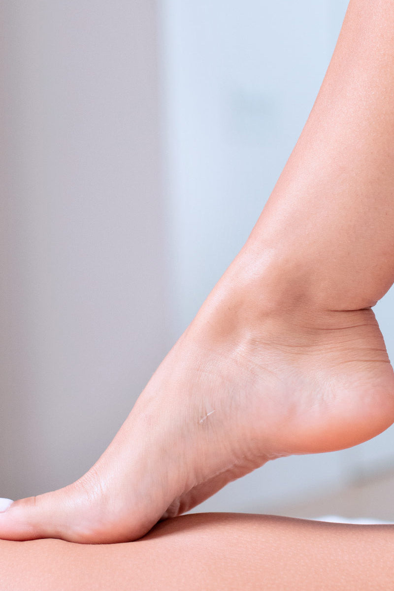 Pie femenino con piel suave y cuidada, descansando sobre la otra pierna, ideal para mostrar los resultados de XERIAL Peel.