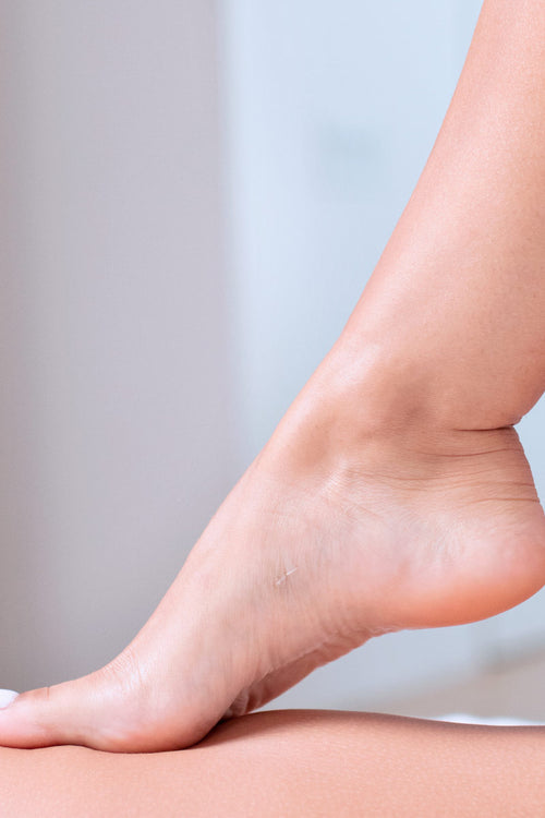 Pie femenino con piel suave y cuidada, descansando sobre la otra pierna, ideal para mostrar los resultados de XERIAL Peel.