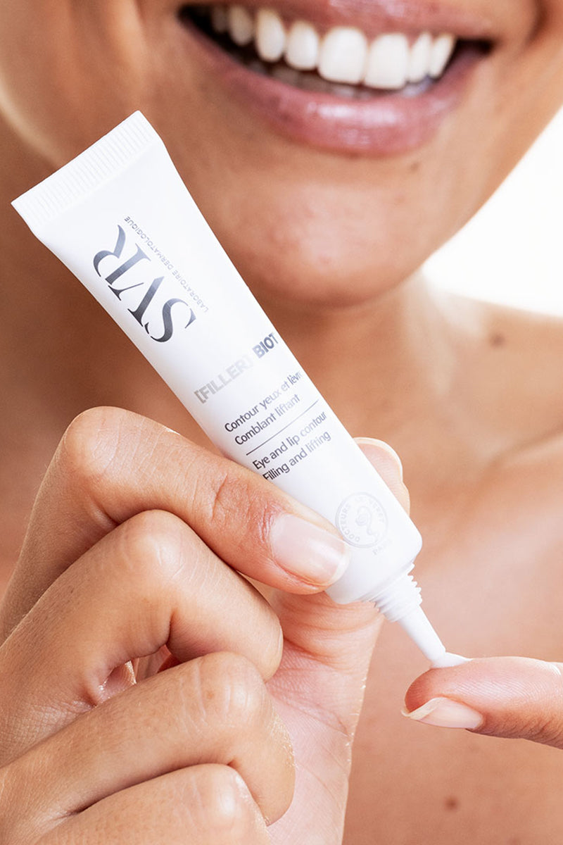 Tubo blanco de 15ml SVR [FILLER] Biotic para contorno de ojos y labios siendo aplicado sobre un dedo.