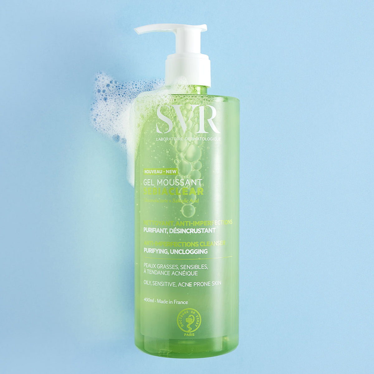 Envase verde de gel limpiador SVR Sebiaclear de 400ml con dosificador blanco y espuma sobre fondo azul claro.