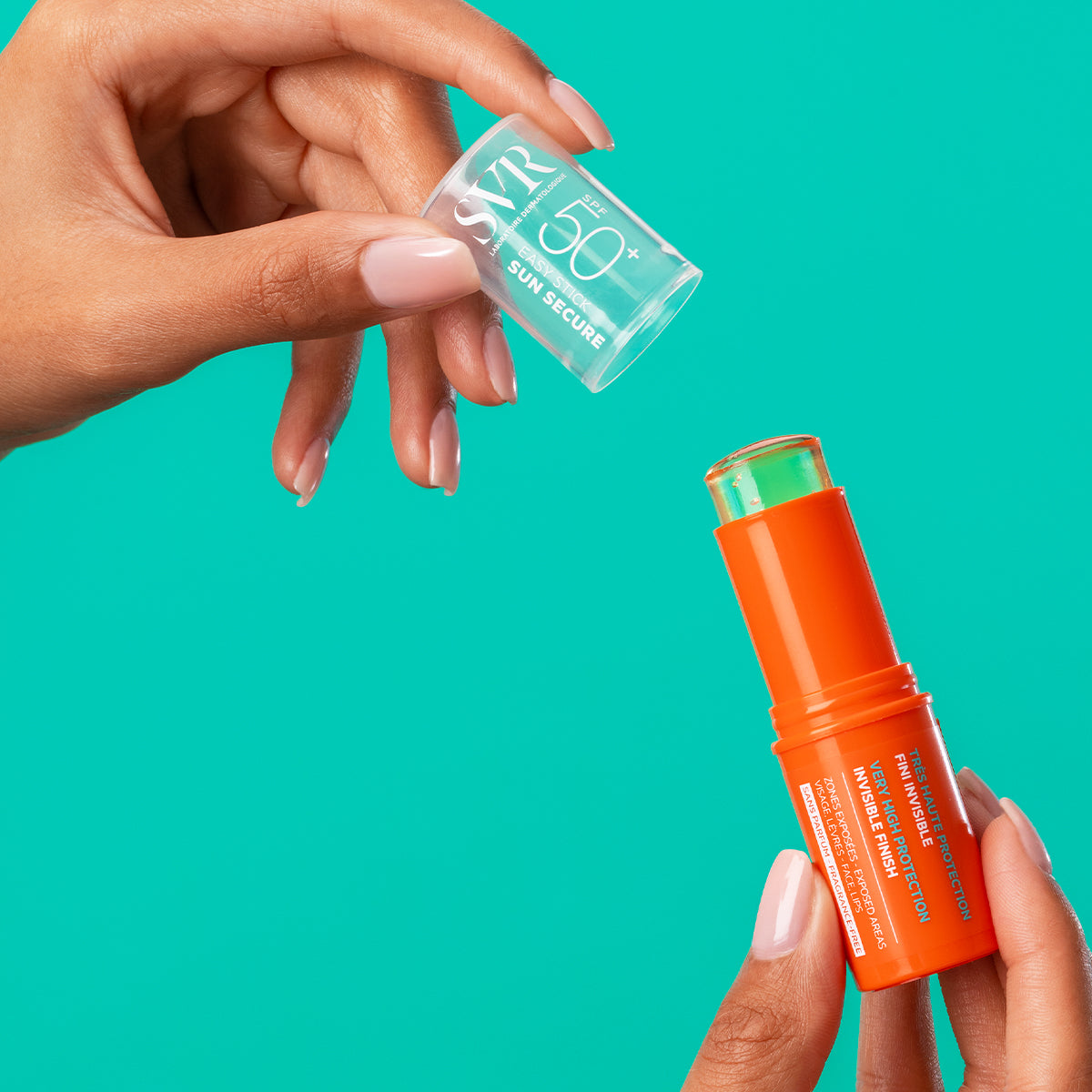 Stick solar SVR SUN SECURE SPF50+ en envase naranja brillante con tapa transparente, sostenido por manos sobre fondo turquesa.