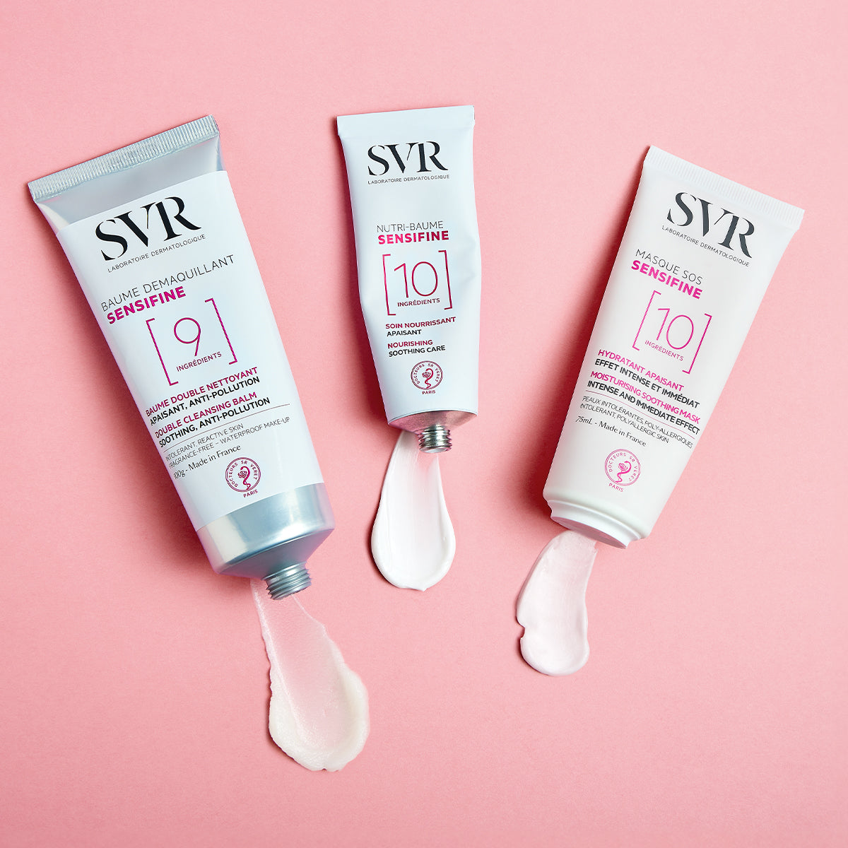 Tres tubos de crema SVR Sensifine blancos con texturas cremosas sobre un fondo rosa suave.
